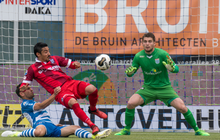 Reza Ghoochannejhad in duel met Bram van Polen. Doelman Mickey van der Hart staat paraat.